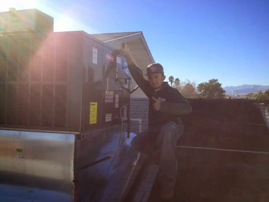 HVAC technician performing AC Tune-Up on a rooftop unit in Hockinson